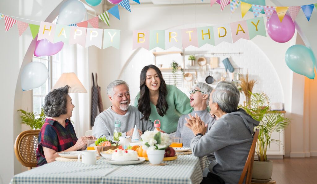 Group of Asian senior people having birthday party at home, celebrating birthday at retirement home with friends